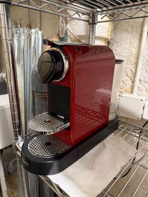 une machine à café rouge posée sur une étagère dans une cuisine
