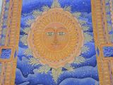 a painting of a sun on the wall of a building