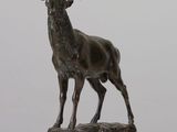 statue of a stag on a rock on a white surface
