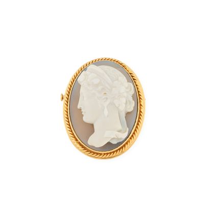 une broche en camée doré et blanc représentant le visage d'une femme