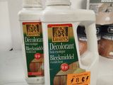 three bottles of decorant on the counter next to a can of wood glue
