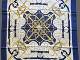 a blue and white scarf with a gold design on it