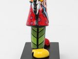 figurine of a woman in a red dress and yellow shoes on a black base