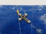 un gros plan d'une croix en or posée sur une dalle de marbre bleu