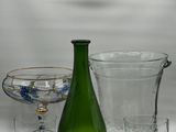 a green bottle and two glasses sitting on a table