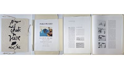 three books are open on a table with papers and a bag