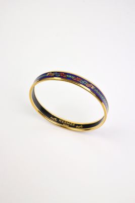 un gros plan sur un bracelet rigide en émail doré et bleu