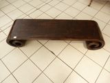 a wooden bench sitting on a tiled floor in a room