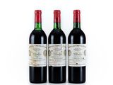 three bottles of red wine sitting next to each other on a white surface