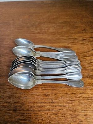 six cuillères en argent et deux cuillères en argent posées sur une table en bois
