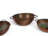three copper pans with handles and handles are sitting on a white surface