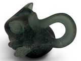 a green glass animal figurine sitting on a white surface