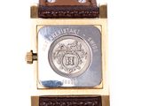 a close up of a wrist watch with a coin on it