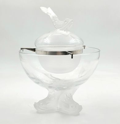 un saladier en verre transparent muni d'un couvercle en argent orné d'un oiseau