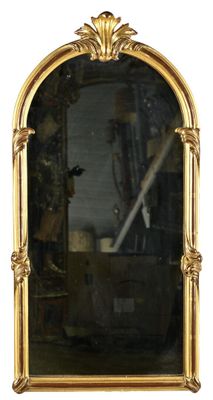 un grand miroir avec un cadre doré accroché au mur