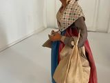 a figurine of a woman with a bag on her shoulder