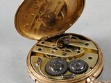 a gold pocket watch with gears inside of it