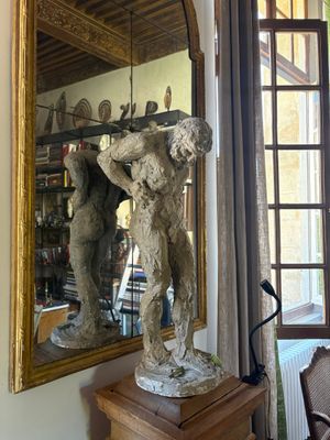 a statue of a man holding a gun in front of a mirror