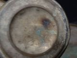 a close up of a metal vase with a rusted surface