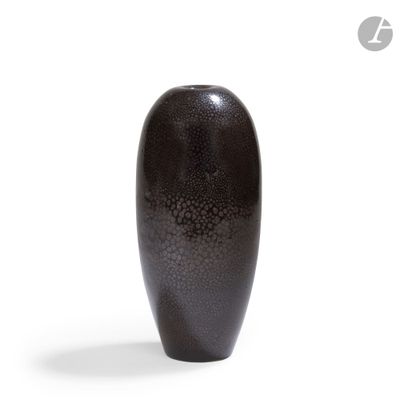 a black vase that is sitting on a white surface