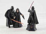 two figurines of darth vader and darth vader sit on a pedestal