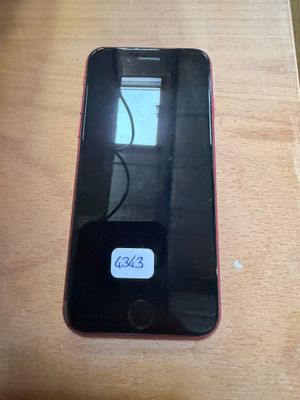 an iphone sitting on top of a wooden table next to a keyboard
