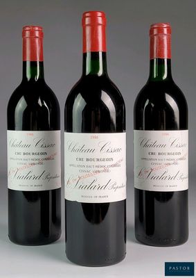 three bottles of red wine are lined up on a table