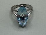 un gros plan d'une bague sertie d'une topaze bleue