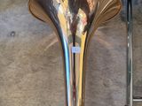 a brass trumpet sitting on the floor next to a ladder