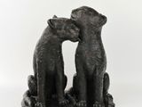 une statue représentant deux ours assis l'un à côté de l'autre