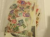 de nombreux timbres différents dans un sachet transparent posé sur une table