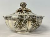 a silver bowl with a lid on a white table