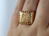 someone is holding a gold ring with a roman numeral on it