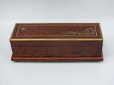 une vieille boîte en bois avec une inscription dessus, posée sur une surface blanche