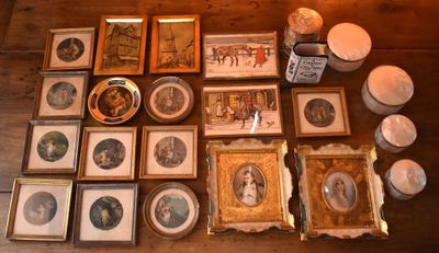a lot of framed pictures on the table with candles