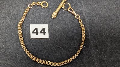 un bracelet en chaîne d'or sur lequel figure le chiffre 44