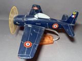 un petit avion en bois posé sur un socle en bois
