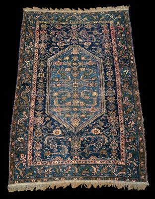 un tapis bleu orné d'un motif en médaillon et de franges