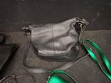 a black purse and a green purse on the floor
