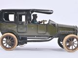 a toy car with two people in it on a white surface