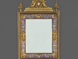 un miroir ouvragé, doté d'un cadre doré et d'un décor bleu et blanc