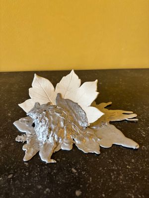 une feuille d'argent posée sur une table, avec un mur jaune en arrière-plan