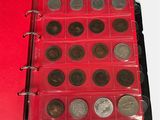 an open red binder with coins in it on a white surface