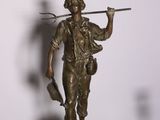 bronze statue of a man holding a spear and a bow