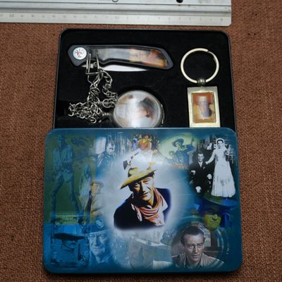 une photo représentant un ensemble d'objets comprenant un couteau, un porte-clés et la photo d'un homme