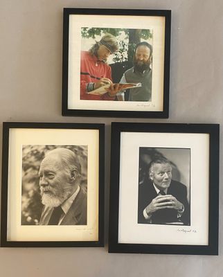 three framed photographs of old men and women are hanging on a wall
