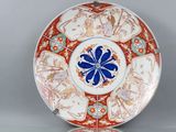 une assiette orange et blanche ornée d'une fleur bleue