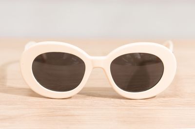 sunglasses on a wooden table with a white background