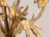 a close up of a gold colored metal candle holder with flowers on it