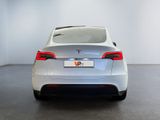 the rear end of a silver tesla vehicle in a white room